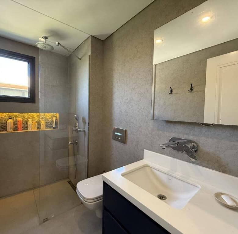 Modern bathroom with walk-in shower and natural light.
