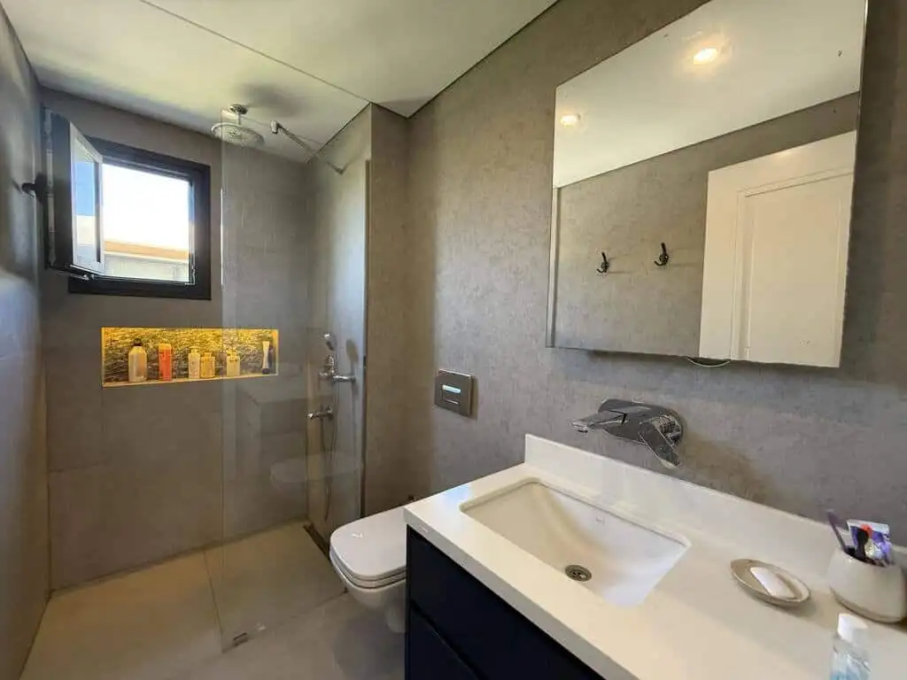 Modern bathroom with walk-in shower and natural light.