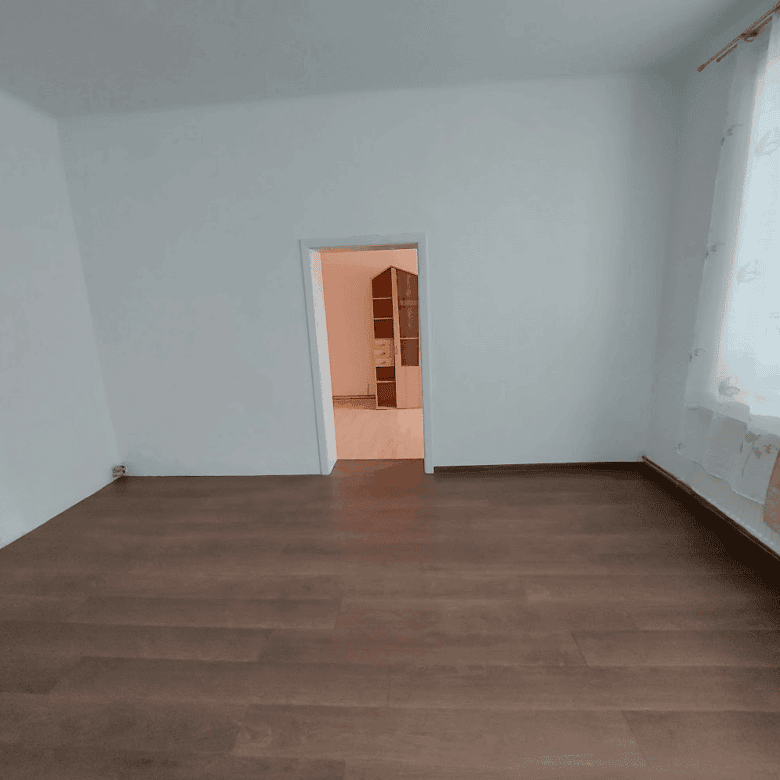 Spacious living room with large window and natural light, ideal for family living.