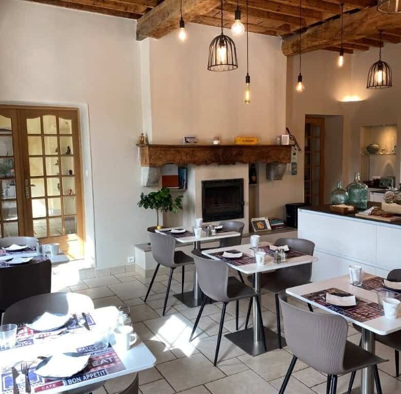 Charming interior of La Maison du Bonheur Bed and Breakfast in Ausson, featuring rustic wooden beams.