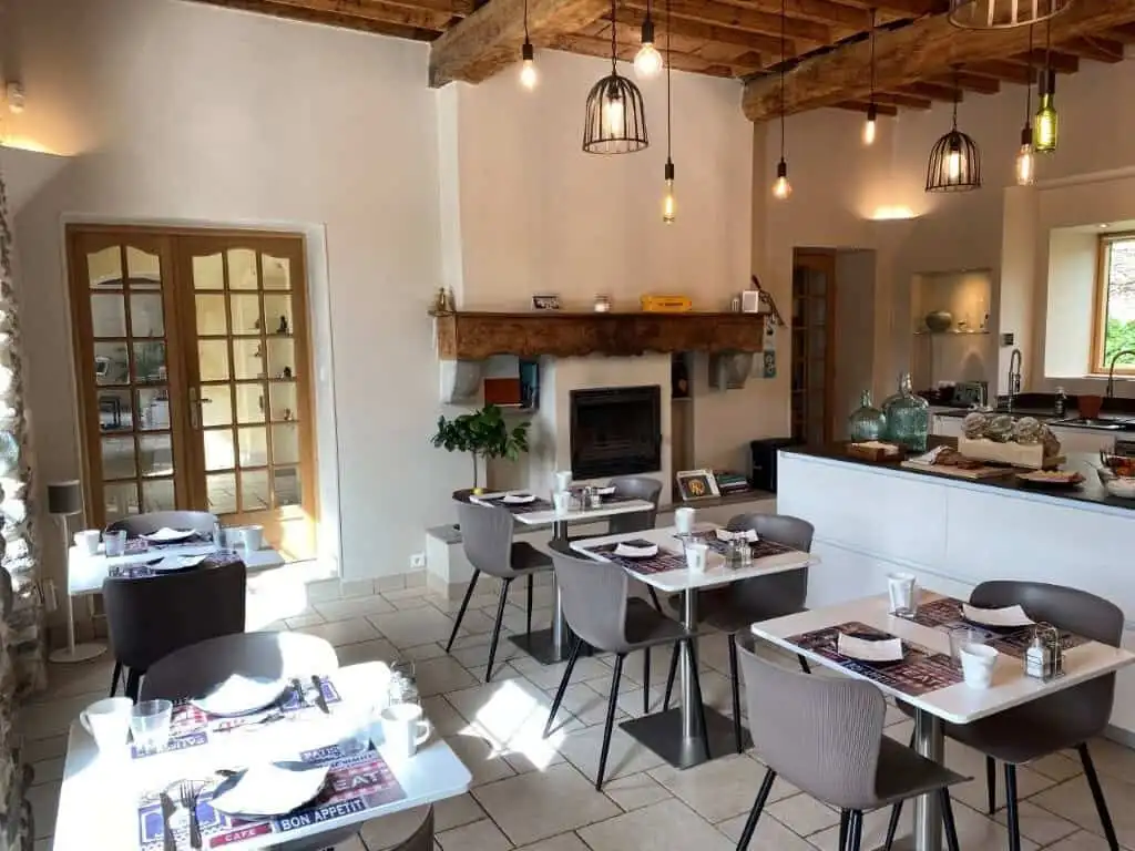 Charming interior of La Maison du Bonheur Bed and Breakfast in Ausson, featuring rustic wooden beams.