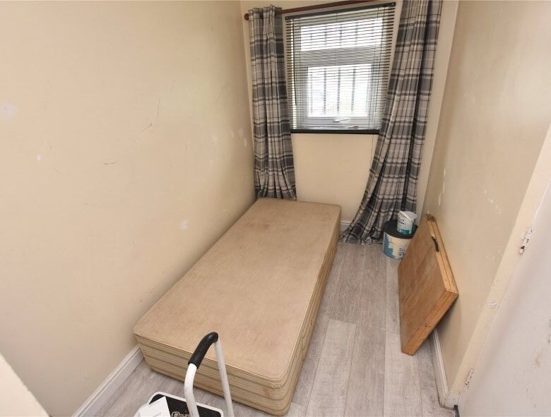 Compact room in Leeds with a single bed and window view, ideal for rental investment.