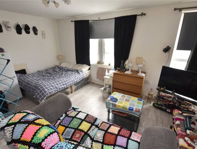 Leeds property for sale: interior view of a furnished flat with tenants, featuring a cozy living roo.