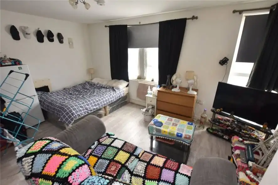 Leeds property for sale: interior view of a furnished flat with tenants, featuring a cozy living roo.