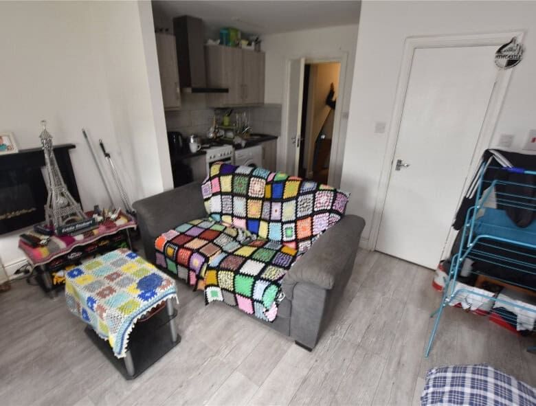 Spacious living room in Leeds property featuring a colorful crochet blanket on the sofa.