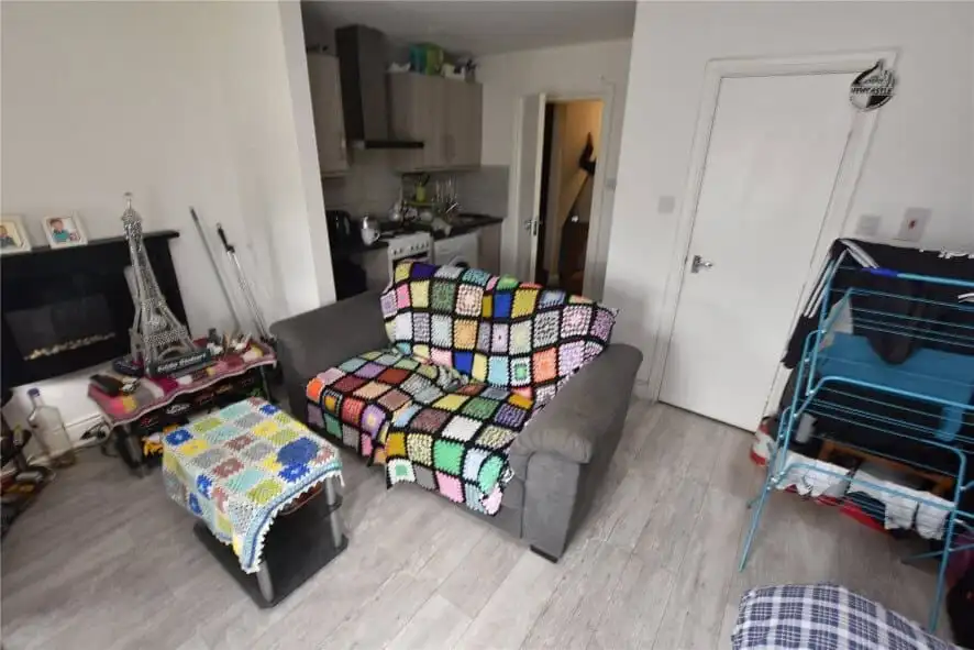 Spacious living room in Leeds property featuring a colorful crochet blanket on the sofa.