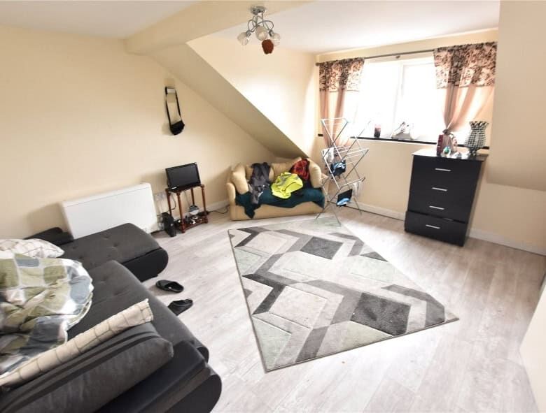 Interior view of a Leeds apartment with tenants, featuring a living room with sofas and a window.
