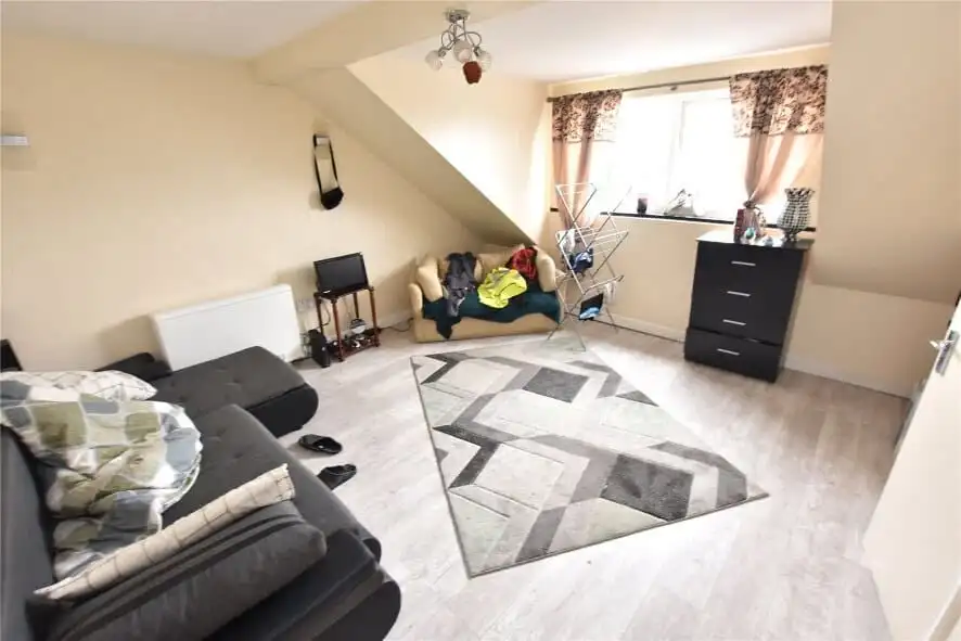 Interior view of a Leeds apartment with tenants, featuring a living room with sofas and a window.