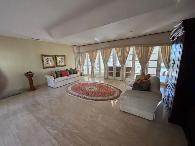 Spacious living room of a luxury 5-bedroom villa in Morning Side, Durban, featuring large windows an.