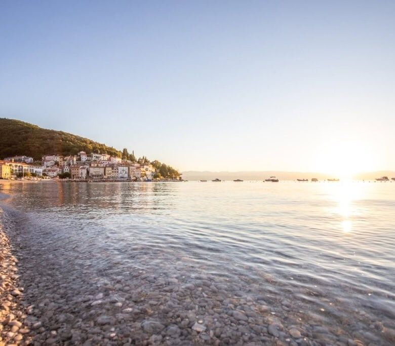 Scenic view of Skrinjari beach in Istria with calm waters and pebble shoreline.