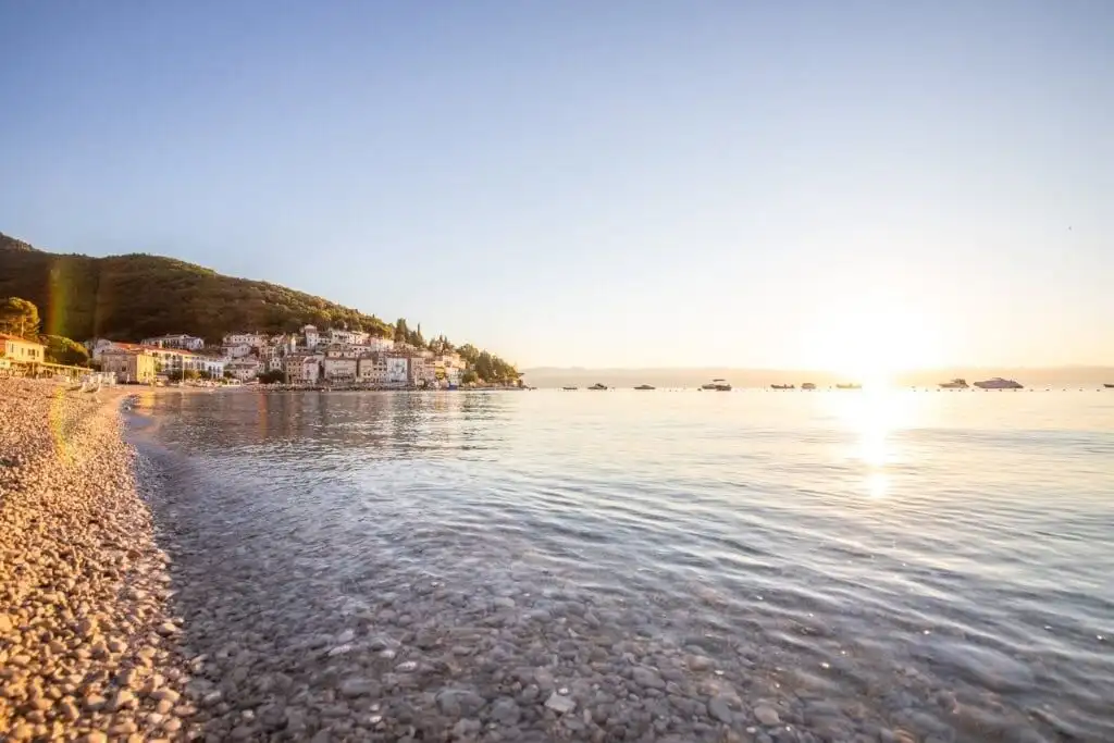 Scenic view of Skrinjari beach in Istria with calm waters and pebble shoreline.