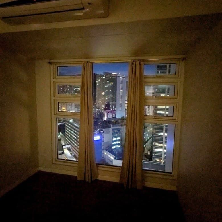 Cityscape view from a 1-bedroom apartment in Kroma Tower, Manila at night.