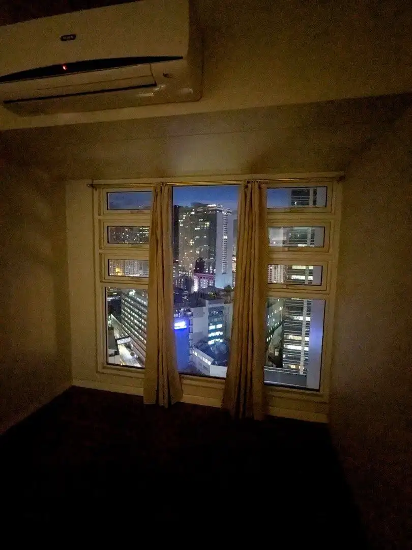 Cityscape view from a 1-bedroom apartment in Kroma Tower, Manila at night.