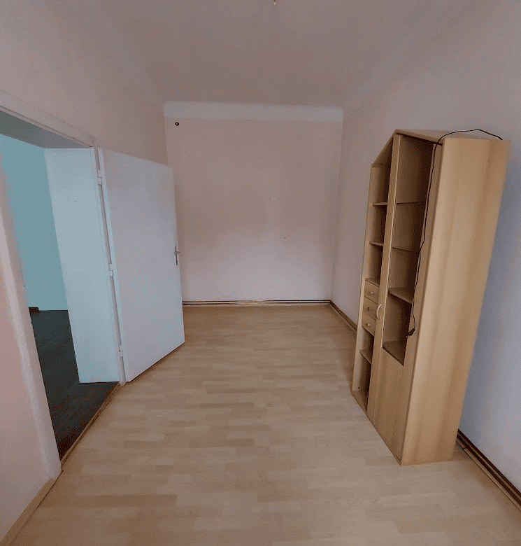 Apartment interior with wooden flooring and a bookshelf in Wilhelmsburg.