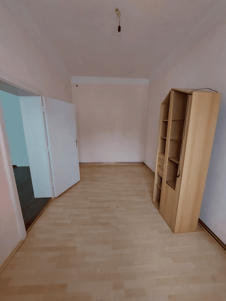 Building with 4 Apartments For Sale in Wilhelmsburg Apartment interior with wooden flooring and a bookshelf in Wilhelmsburg.