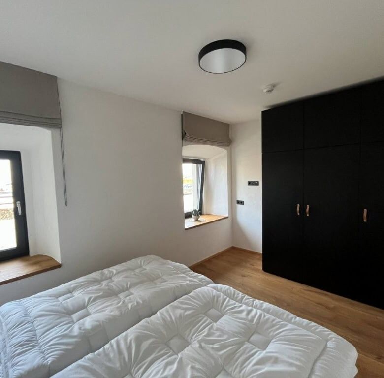 Spacious bedroom featuring two beds and a large wardrobe in a luxury apartment in Rattendorf.