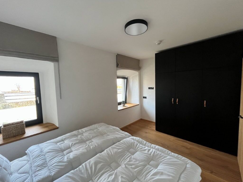 Modern bedroom with two beds and large wardrobe in Rattendorf apartment Spacious bedroom featuring two beds and a large wardrobe in a luxury apartment in Rattendorf.