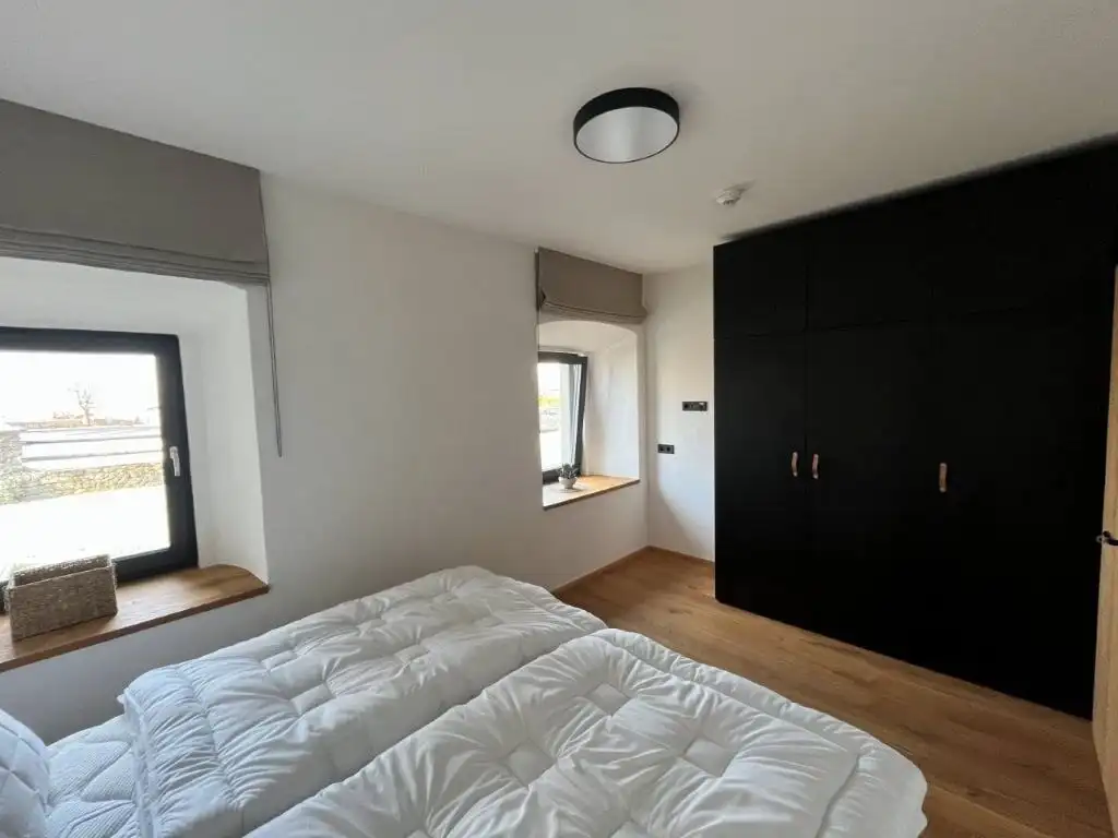 Spacious bedroom featuring two beds and a large wardrobe in a luxury apartment in Rattendorf.