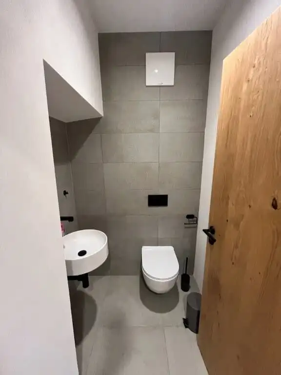 Compact bathroom with modern toilet and sink in a luxury apartment in Rattendorf.