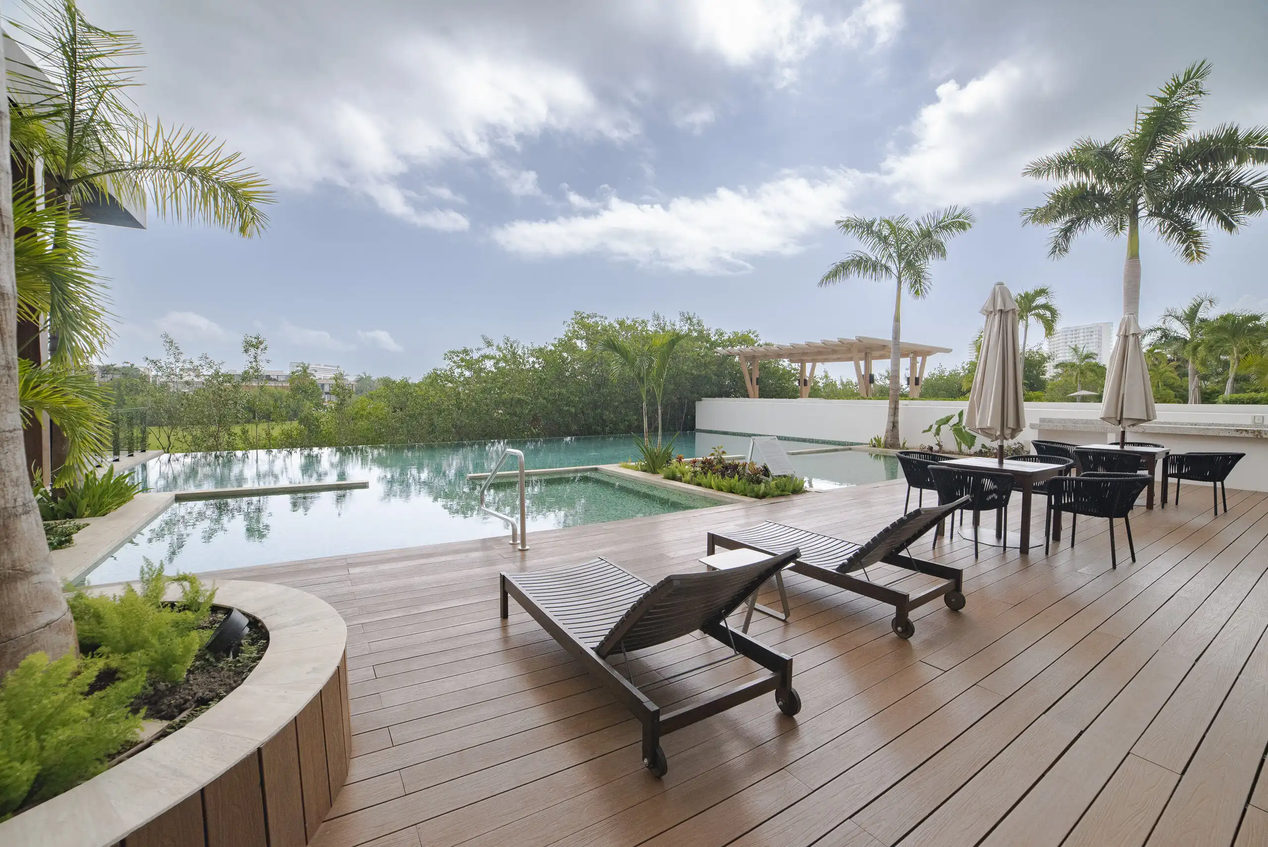 Elegant poolside view of a luxury 4-bedroom apartment in Cancun. Perfect for relaxing and enjoying t.