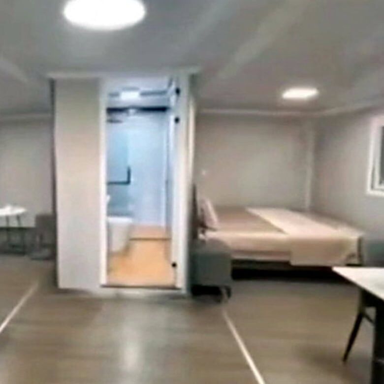 Modern hotel room interior with a bed, seating area, and bathroom on the island of Martinique.
