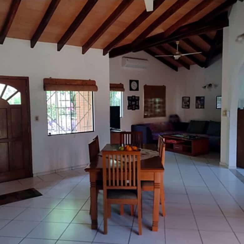 Interior view of a living room with wooden ceiling and dining area in Pirayu, Paraguay.