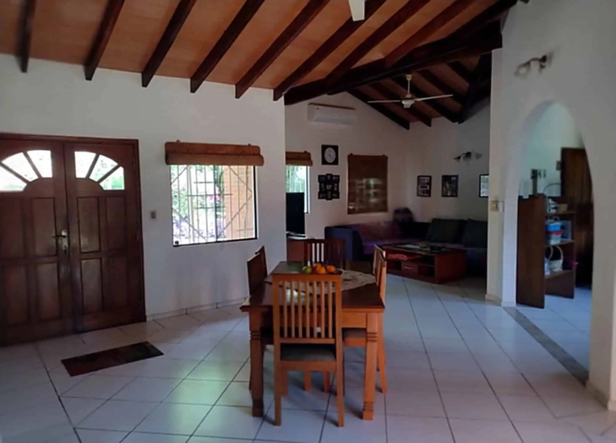 Interior view of a living room with wooden ceiling and dining area in Pirayu, Paraguay.