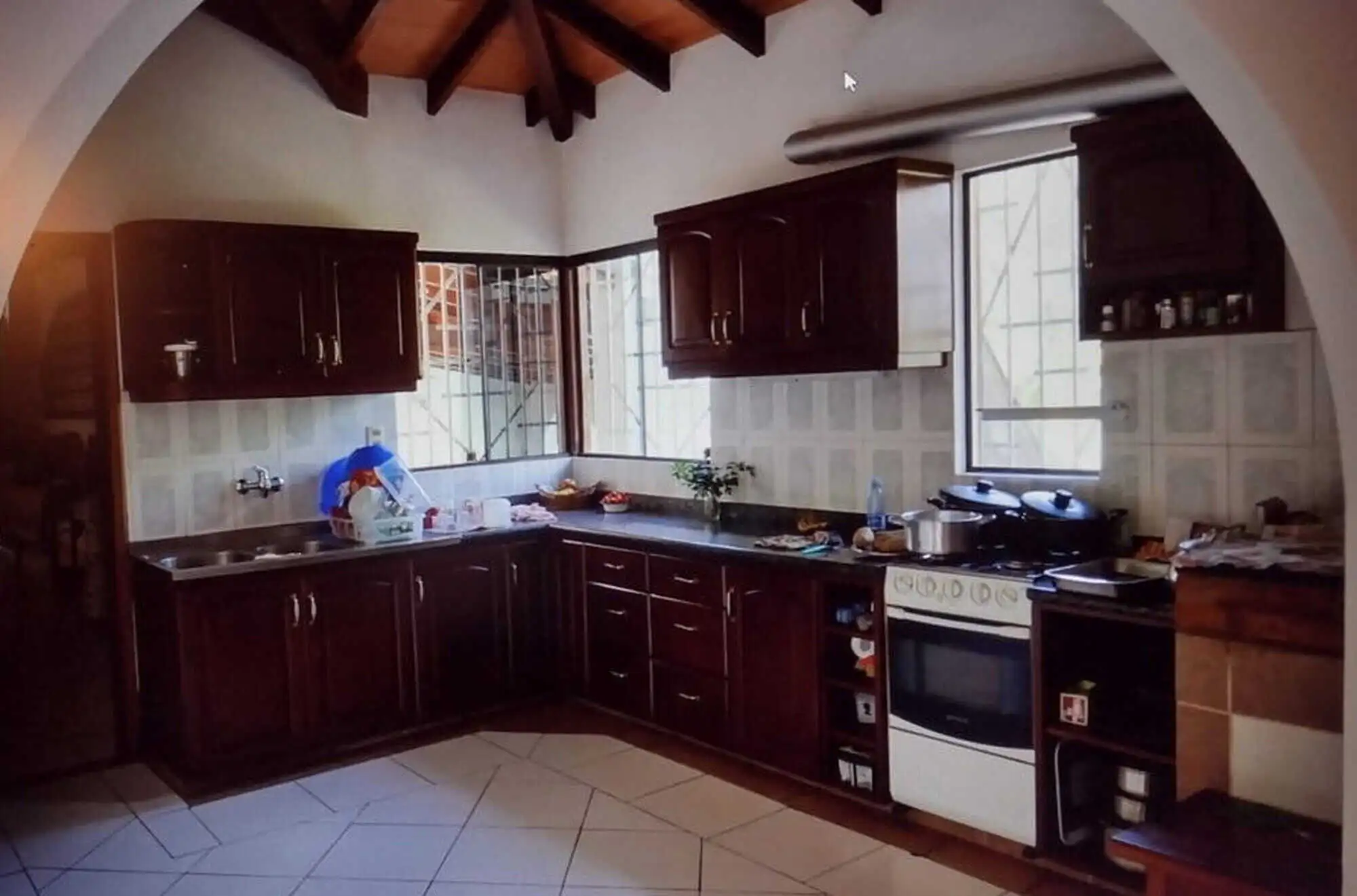 Spacious kitchen in a property with two houses and land in Pirayu, Paraguay, featuring dark wood cab.