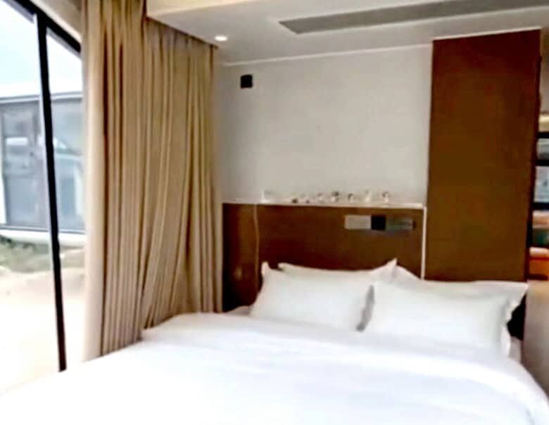Modern bedroom with large window and scenic views in Martinique property.