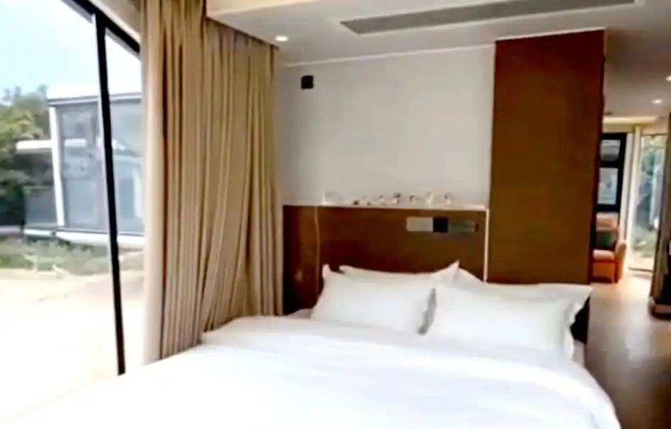 Modern bedroom with large window and scenic views in Martinique property.