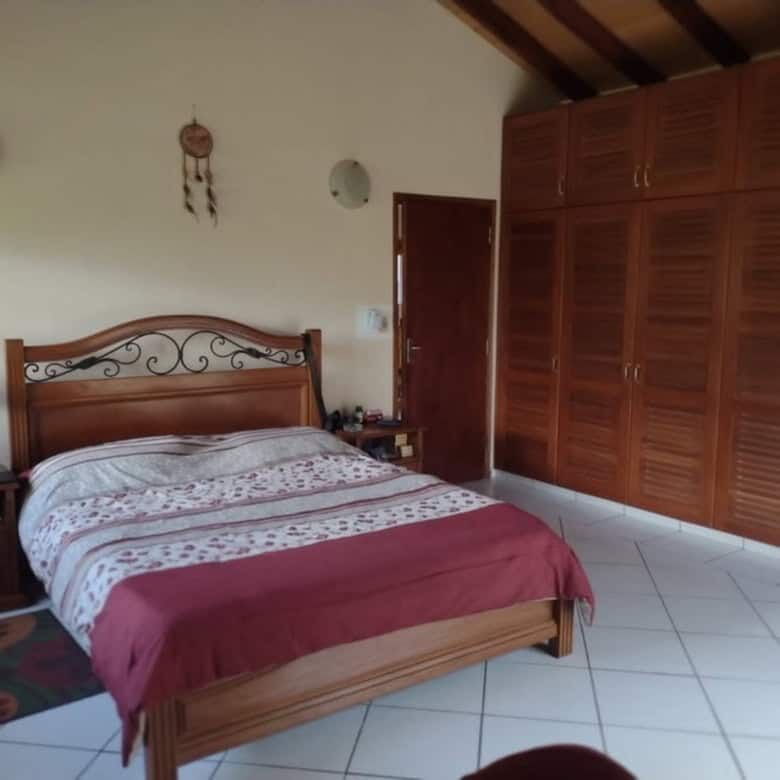 Spacious bedroom with wooden furniture and large wardrobe in Pirayu, Paraguay.