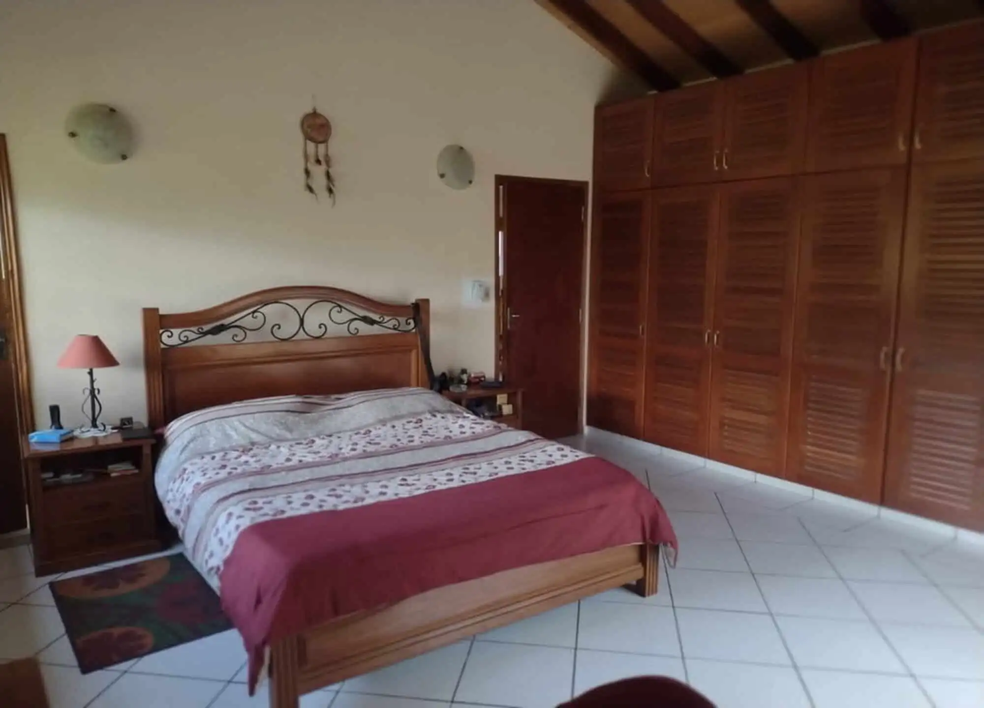 Spacious bedroom with wooden furniture and large wardrobe in Pirayu, Paraguay.