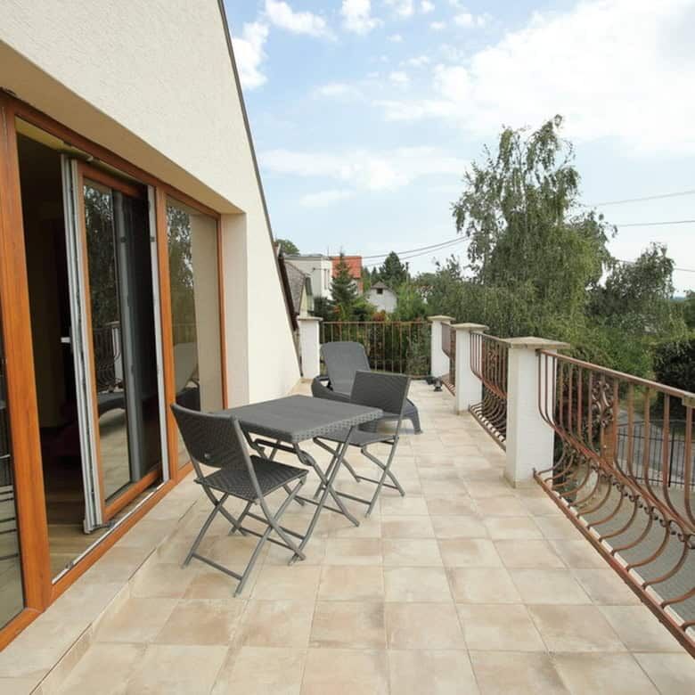 Balcony with outdoor seating overlooking vineyards and surrounding landscape in Vinica, Slovakia.