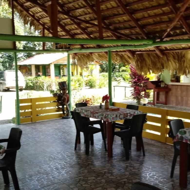 Beachside restaurant with thatched roof in the Dominican Republic, offering a tropical dining experi.