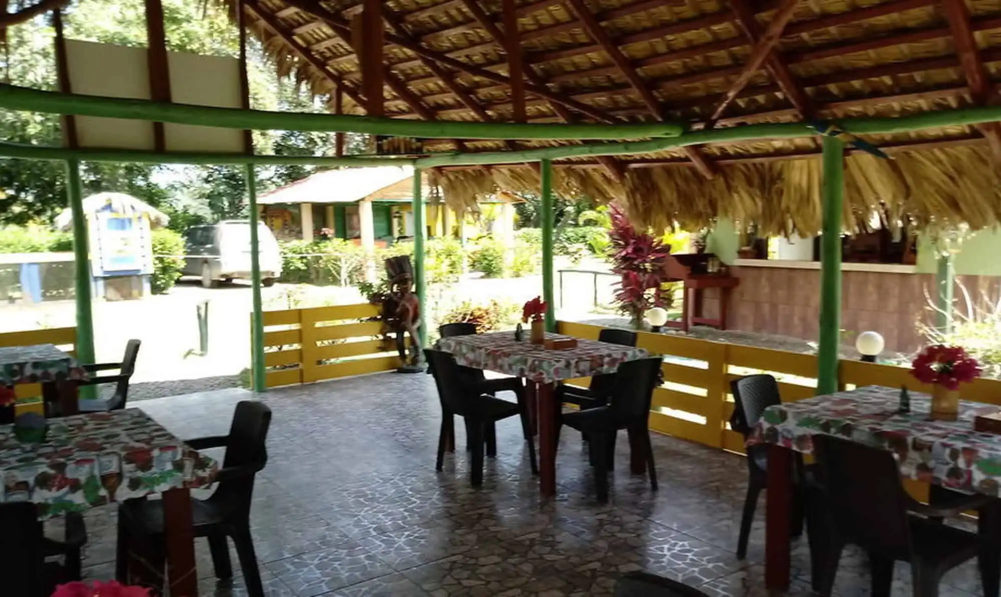 Beachside restaurant with thatched roof in the Dominican Republic, offering a tropical dining experi.