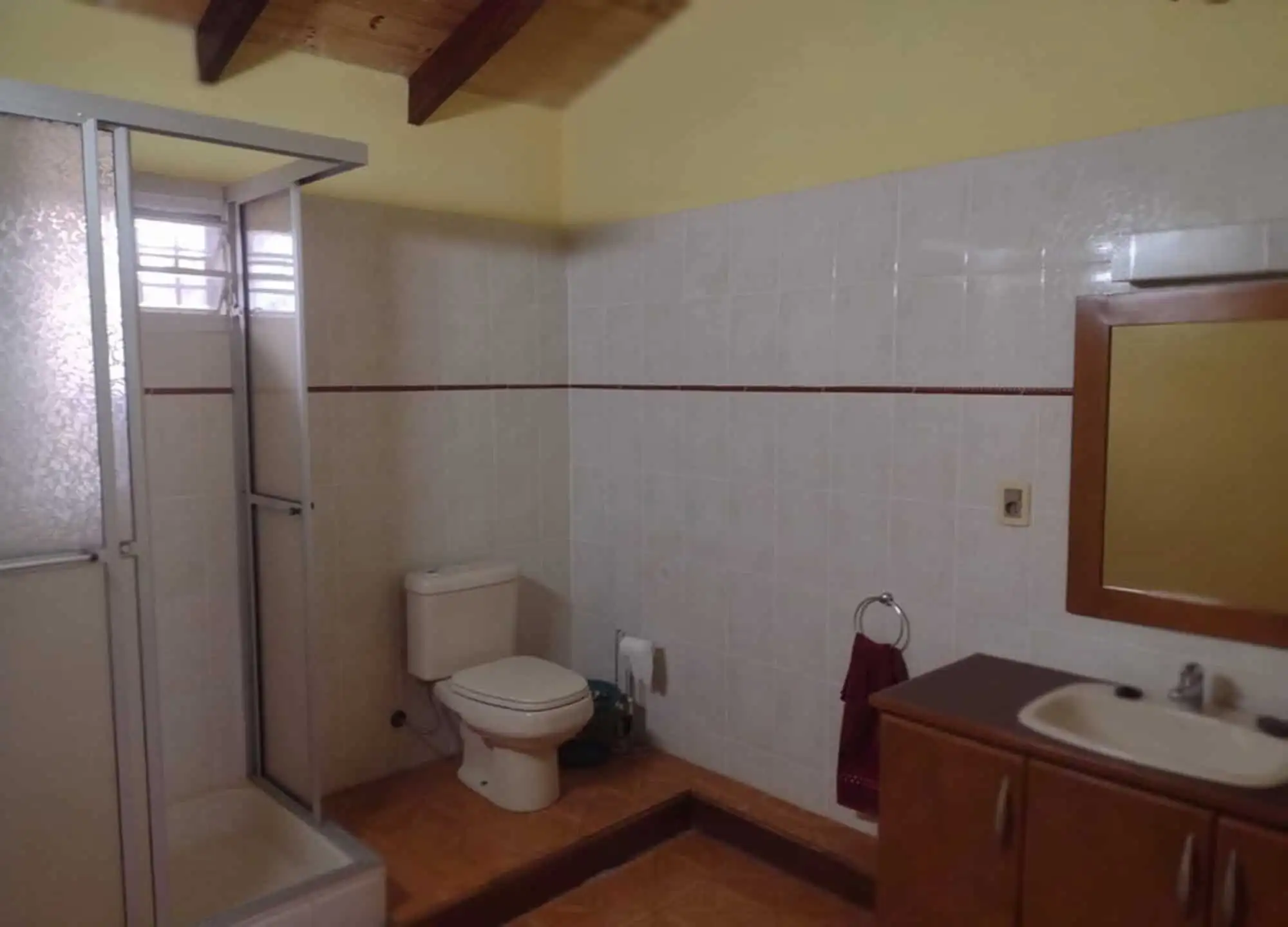 Spacious bathroom with toilet, sink, and shower in a property located in Pirayu, Paraguay.