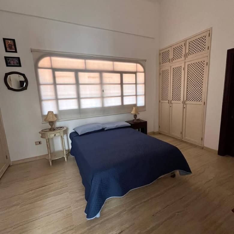 Comfortable bedroom featuring a large window, wardrobe, and minimalist decor on Margarita Island.