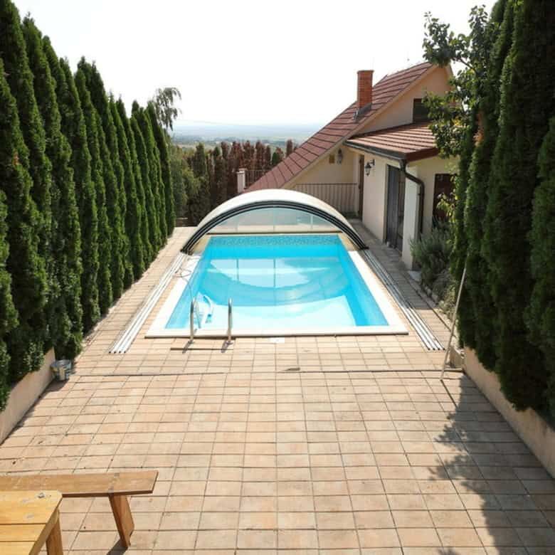 Outdoor swimming pool with surrounding terrace and lush greenery in Vinica, Slovakia.