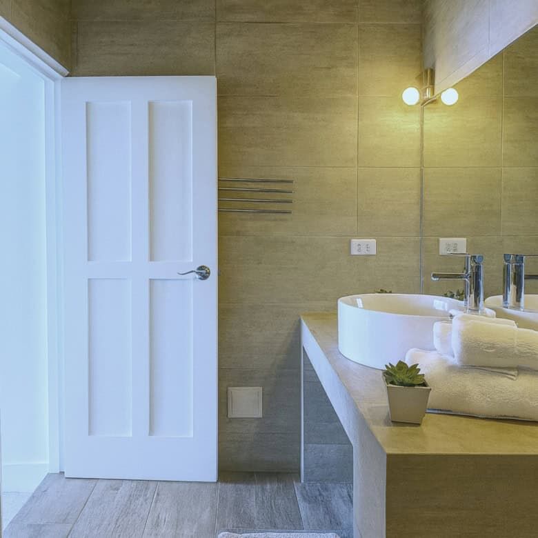 Bathroom with double sinks, mirror, and contemporary design.