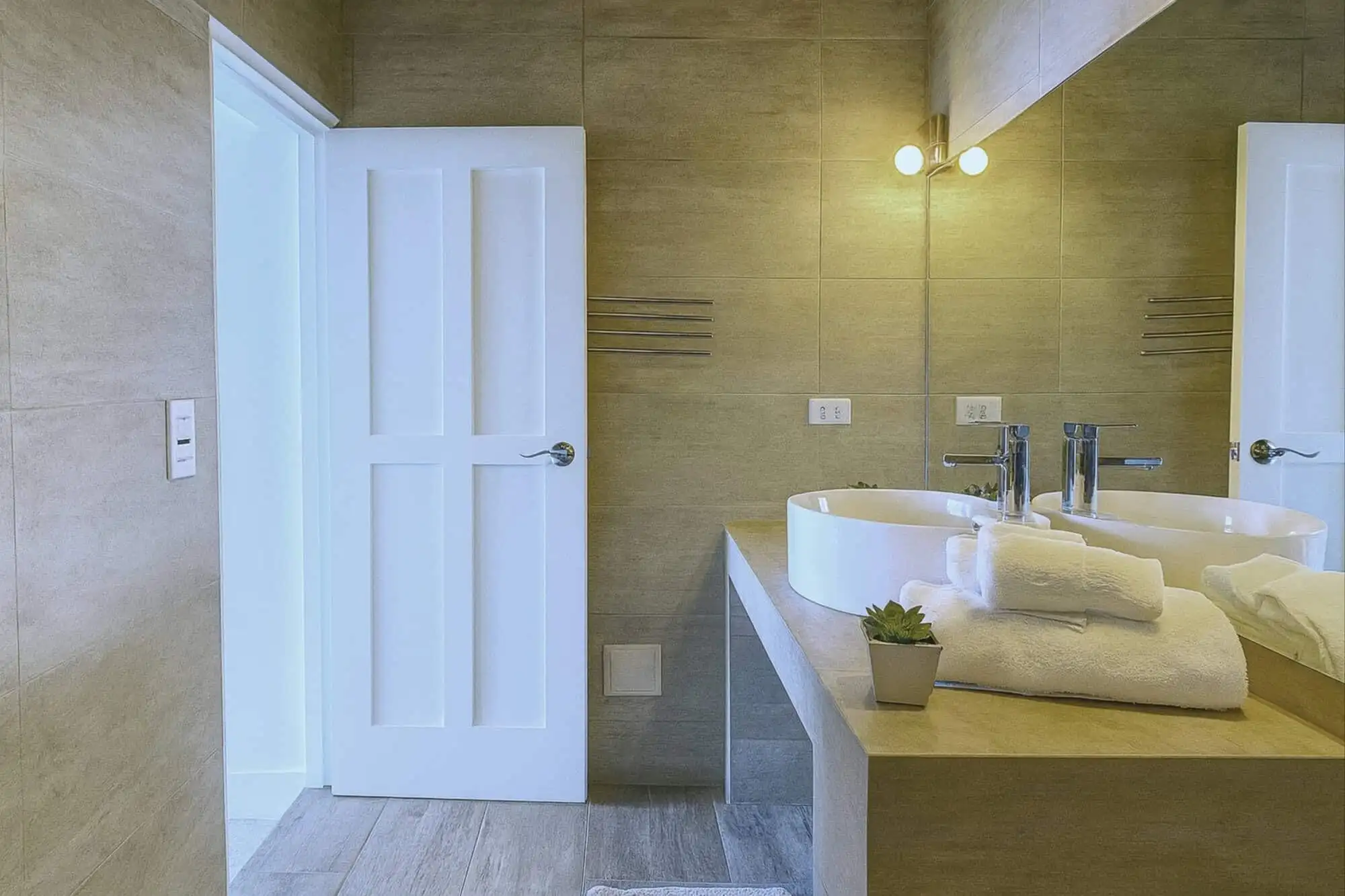 Bathroom with double sinks, mirror, and contemporary design.