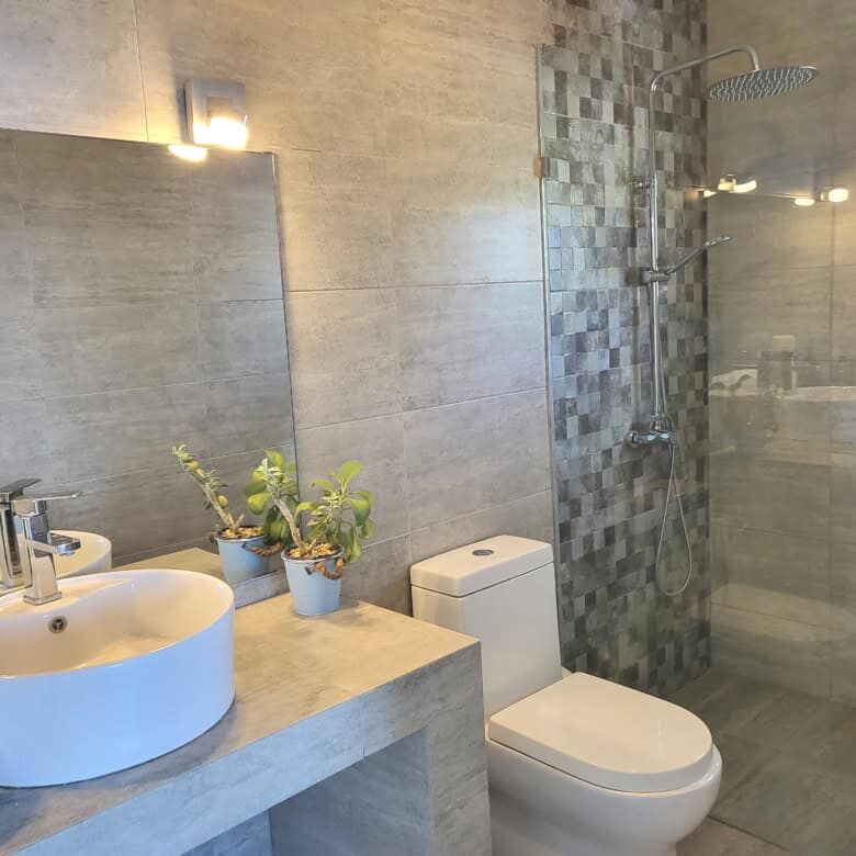 Luxurious bathroom featuring dual sinks, walk-in shower, and elegant design in Sosua estate.