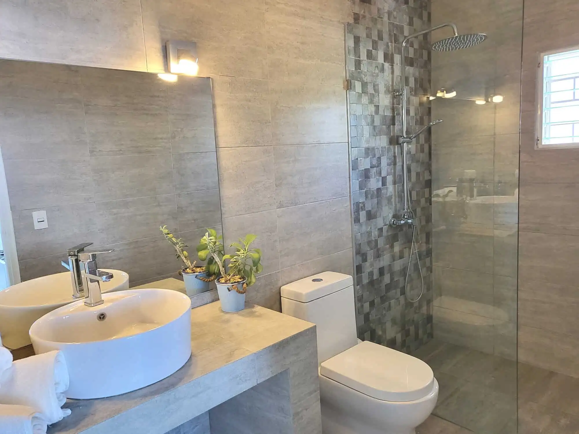 Luxurious bathroom featuring dual sinks, walk-in shower, and elegant design in Sosua estate.