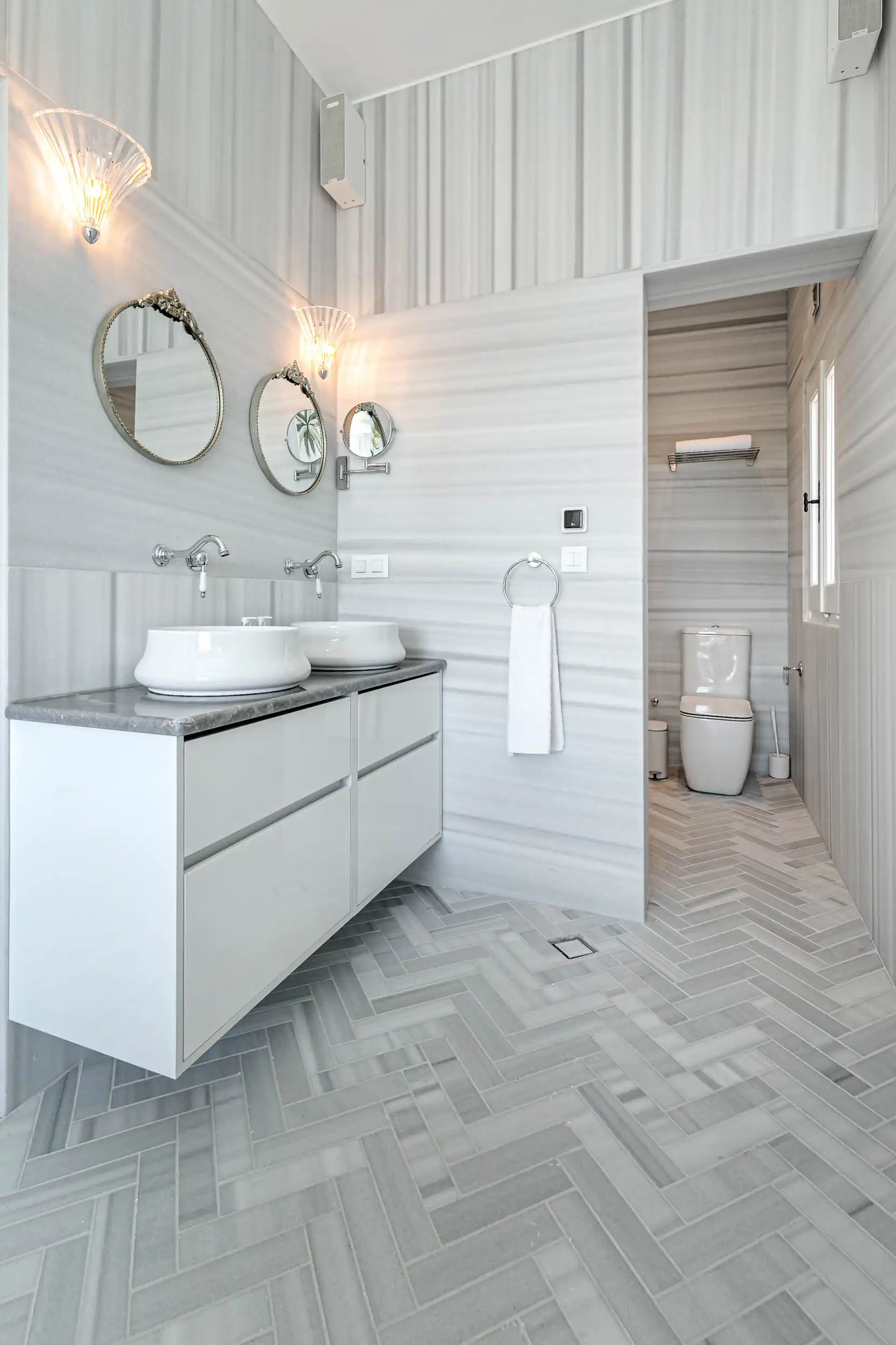 Luxury Villa Bathroom with Modern Design and Sea Views Modern bathroom with double sinks, stylish mirrors, and sea-view window in a luxury villa.
