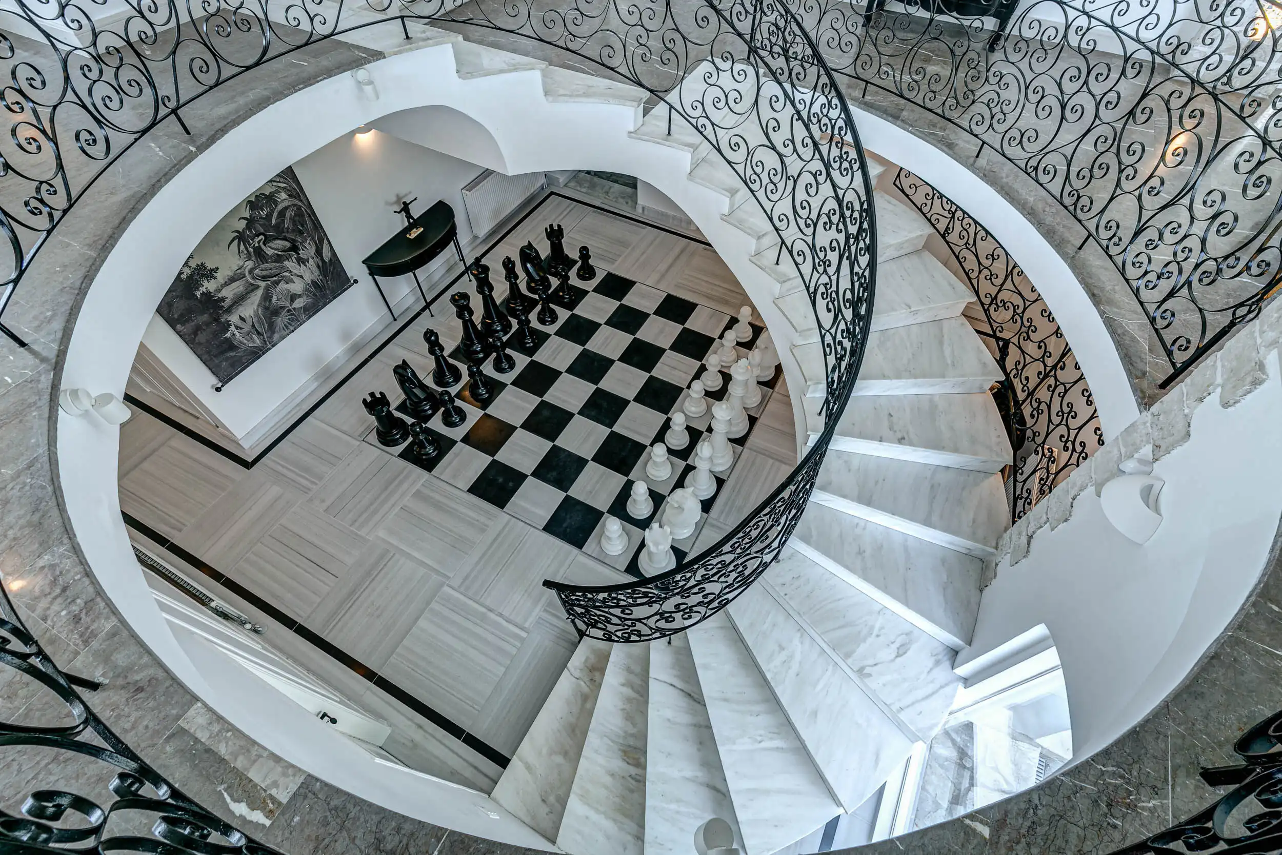 Luxury 6-Bedroom Sea-View Villa in Gouvia, Corfu Elegant interior of a luxury villa with a spiral staircase and chessboard floor.