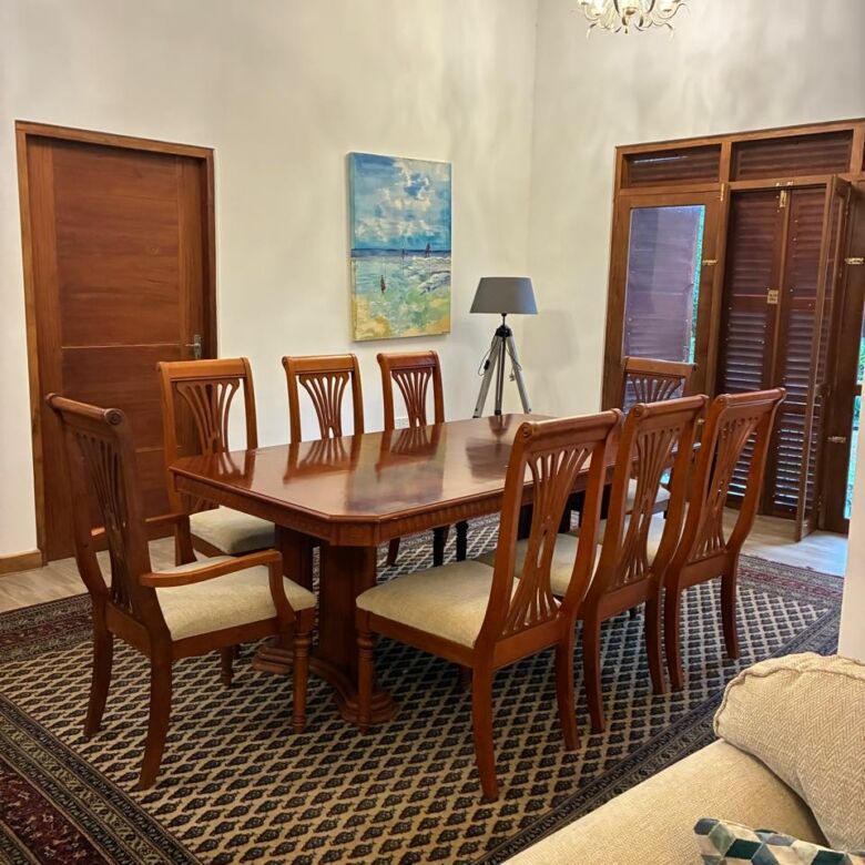 Spacious dining area featuring a large wooden table and eight chairs, perfect for family gatherings.