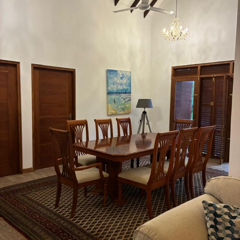 Elegant dining room with high ceilings, wooden doors, and stylish lighting fixtures in Waikkal Sri.