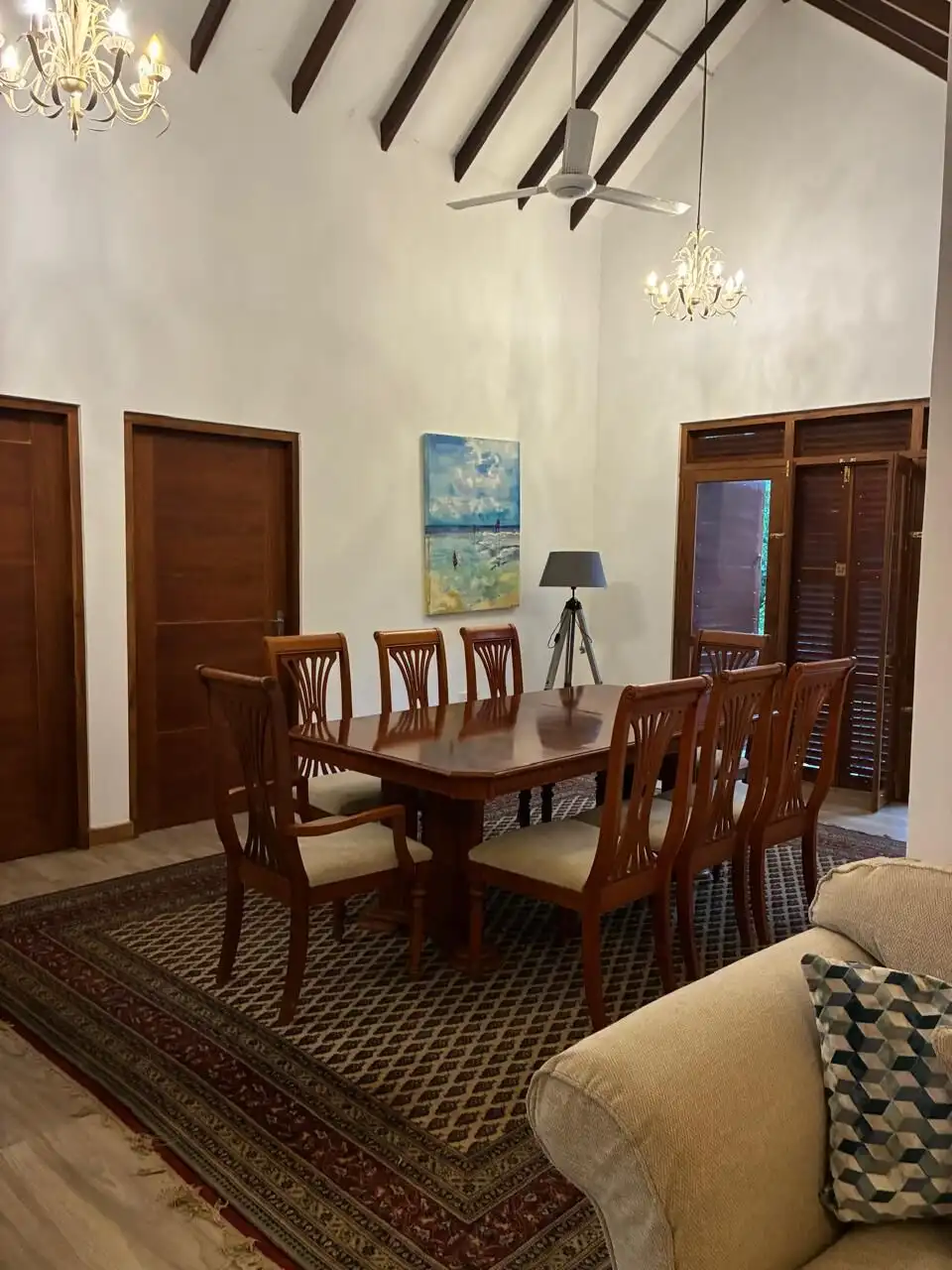 Elegant dining room with high ceilings, wooden doors, and stylish lighting fixtures in Waikkal Sri.