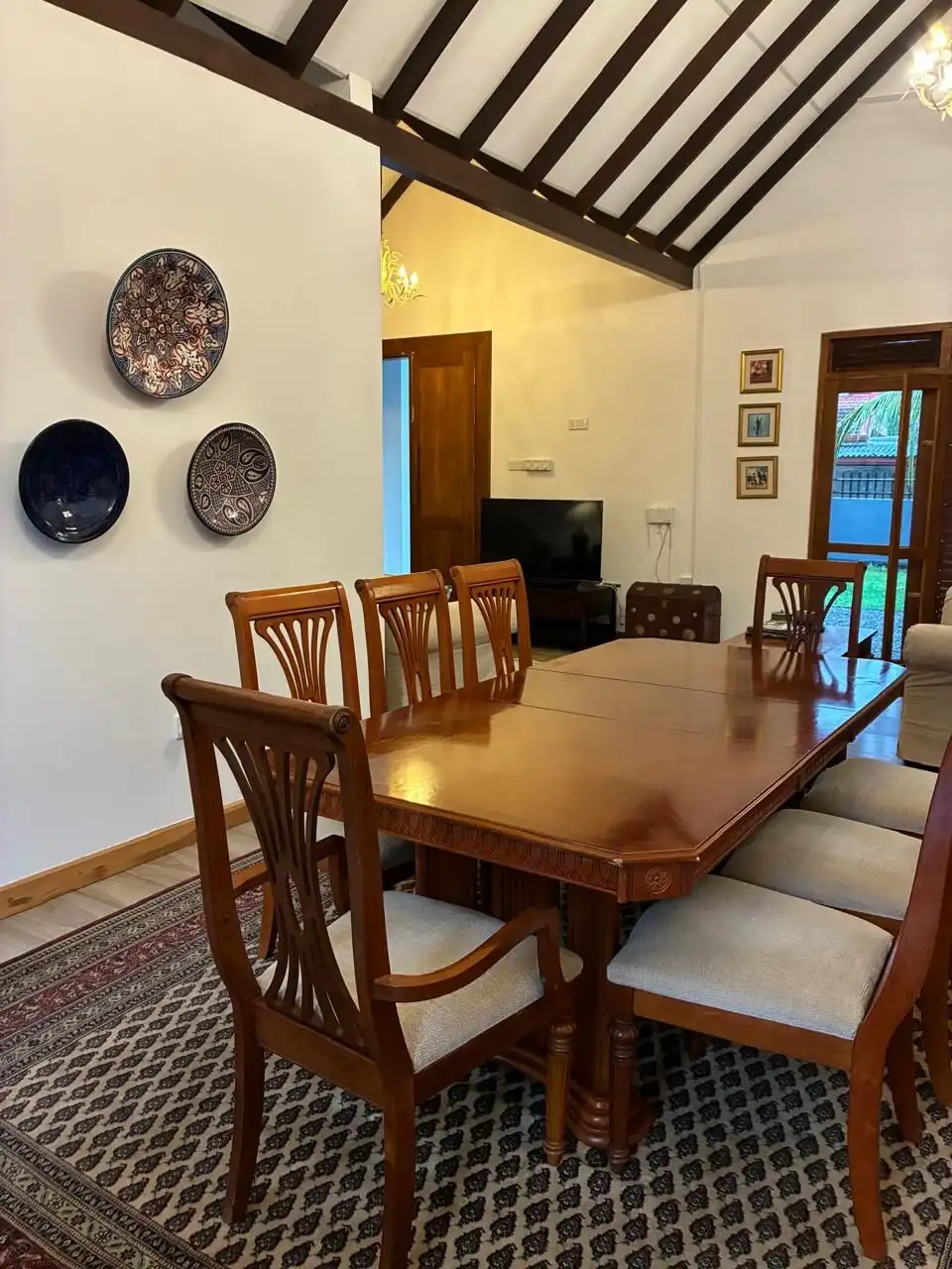 Elegant dining room featuring a wooden table, chairs, and wall decor in a cozy home setting.