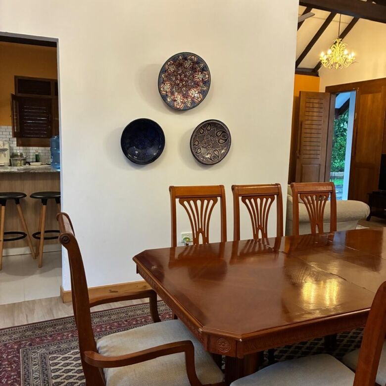Elegant dining room featuring a wooden table and chairs, decorated with artistic wall plates in a co.