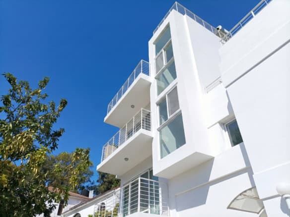 Contemporary white villa with multiple balconies in Sosua, Dominican Republic.